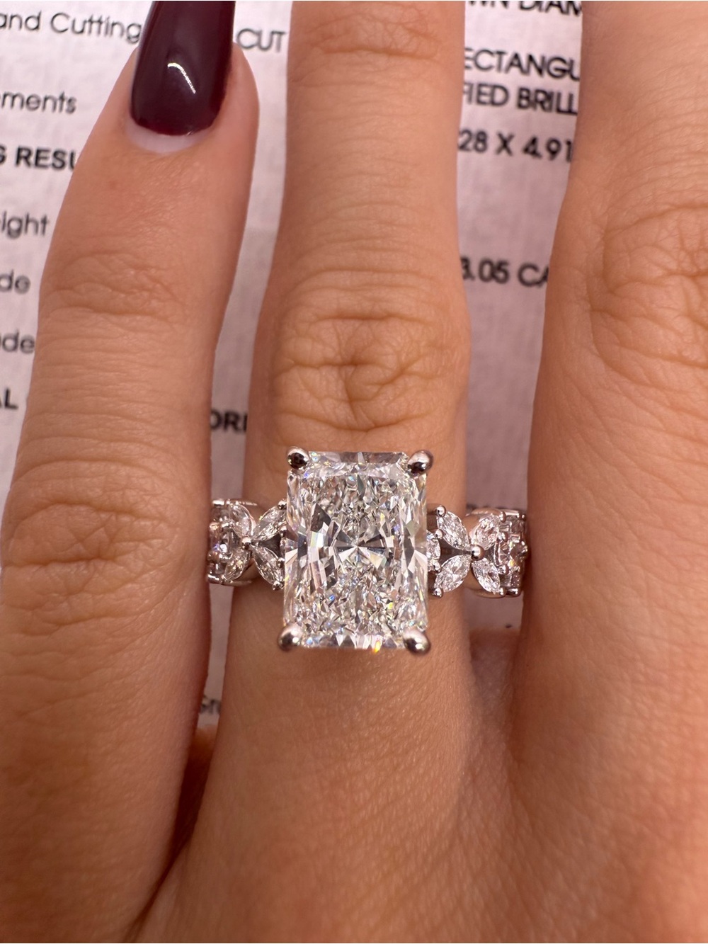 3.05 carat E VS1 radiant cut diamond ring with floral marquise and round diamond
